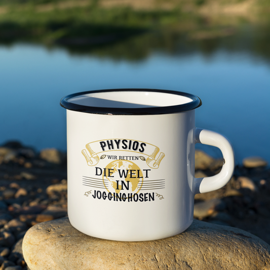 Weiße Emaille Tasse mit schwarzem Rand und dem Spruch „Physios retten die Welt in Jogginghosen“. Steht auf einem Stein und im Hintergrund ist ein See zu sehen. – perfektes Geschenk für Physiotherapeuten.